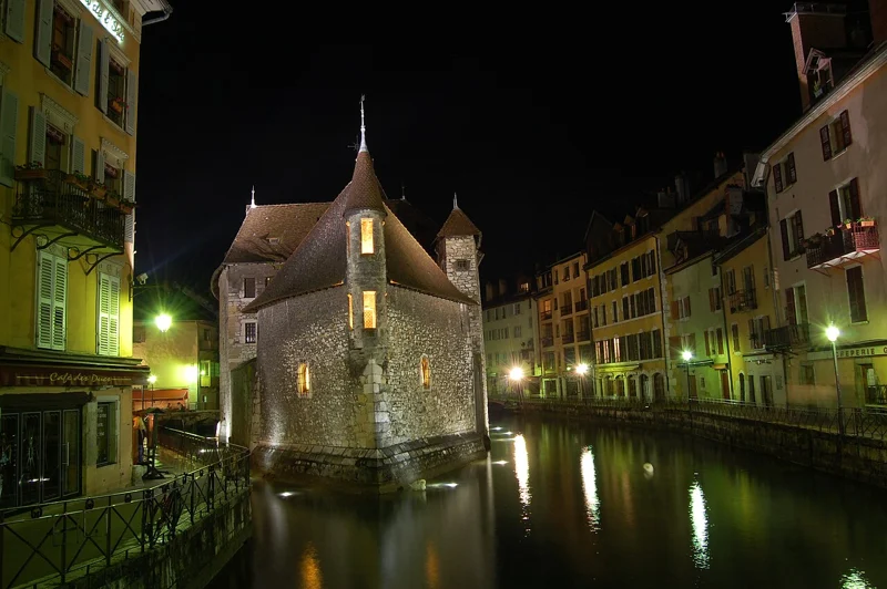 The illuminated Palais de l’Île beside Annecy’s old-town waterways at night