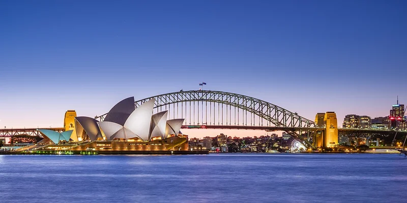 Sydney Opera House and Harbour Bridge across the water at dusk